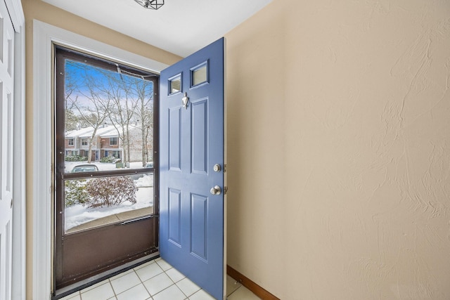 doorway to outside with light tile patterned floors