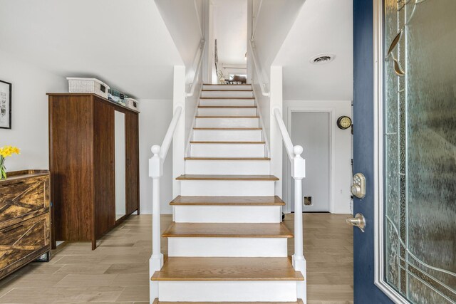 stairway with visible vents and wood finished floors