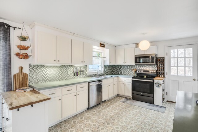 kitchen featuring white cabinets, a sink, stainless steel appliances, and backsplash
