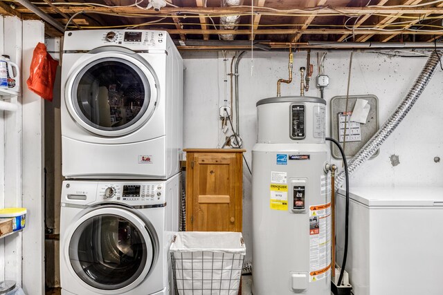 clothes washing area with water heater, laundry area, and stacked washer / drying machine