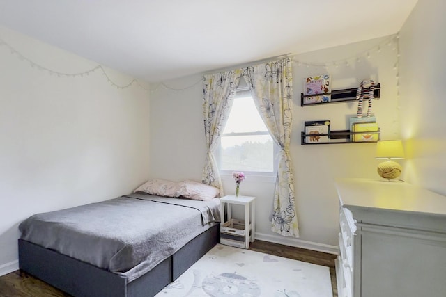 bedroom featuring baseboards and wood finished floors