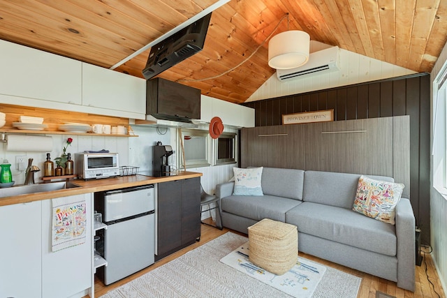 963 Commercial St Unit U30, Provincetown, MA 02657 - kitchen with vaulted ceiling, wood ceiling, light wood-style flooring, white fridge, and wooden walls