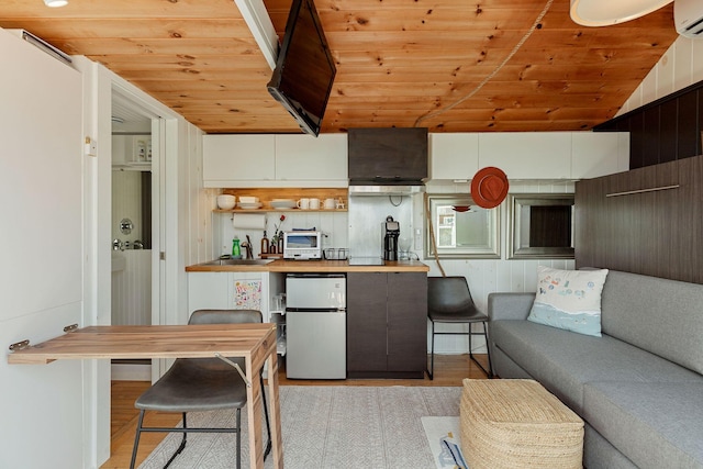 963 Commercial St Unit U30, Provincetown, MA 02657 - kitchen with fridge, wooden ceiling, light wood finished floors, a wall mounted AC, and lofted ceiling