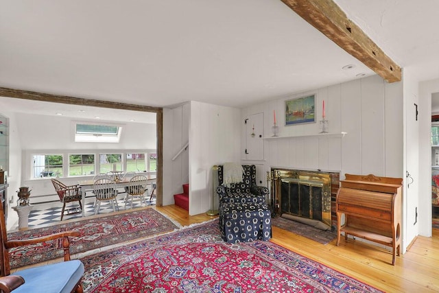 181 Pleasant St, South Yarmouth, MA 02664 - living room with a fireplace with flush hearth, light wood-type flooring, beam ceiling, stairway, and baseboard heating