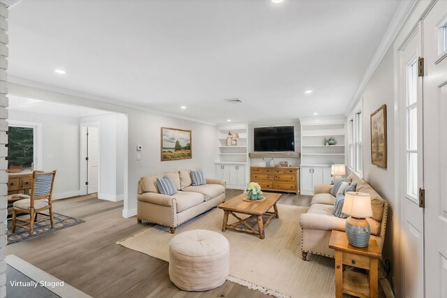 living room featuring crown molding and light hardwood / wood-style flooring