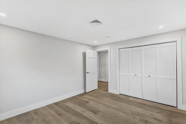 unfurnished bedroom with a closet and light wood-type flooring