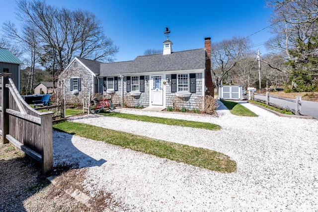 21 Nickerson Rd Unit 3, Cotuit, MA 02635 - view of front of home featuring a chimney, a shingled roof, and stone siding
