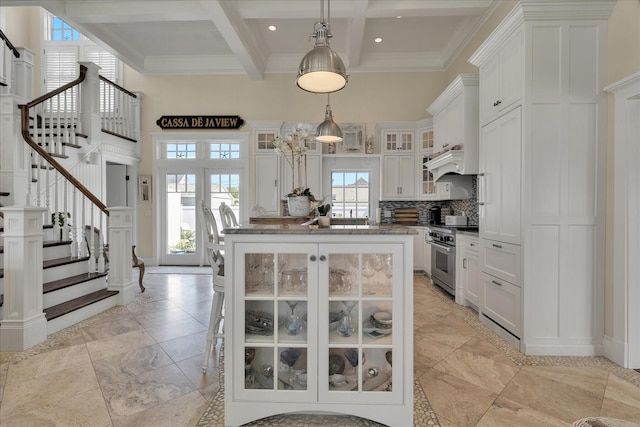 16 Beach View Rd, West Dennis, MA 02670 - kitchen with high end range, a towering ceiling, beamed ceiling, white cabinetry, and a center island