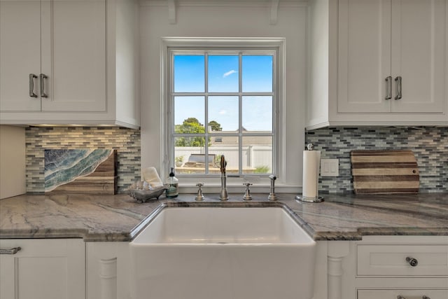 16 Beach View Rd, West Dennis, MA 02670 - kitchen featuring white cabinets, a sink, decorative backsplash, and stone counters