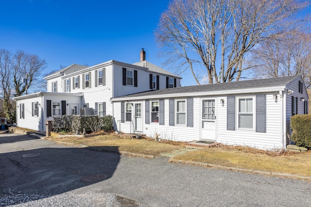 view of front of home featuring entry steps and a chimney