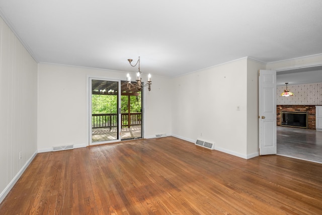 272 Sheep Pond Dr, Brewster, MA 02631 - empty room with a chandelier, wood finished floors, baseboards, crown molding, and a glass covered fireplace