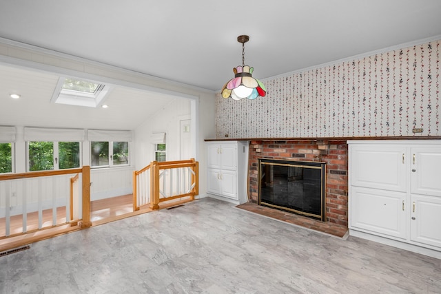 272 Sheep Pond Dr, Brewster, MA 02631 - unfurnished living room featuring a skylight, wallpapered walls, a fireplace, lofted ceiling, and crown molding