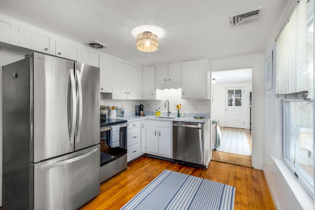 429 Paines Creek Rd, Brewster, MA 02631 - kitchen with appliances with stainless steel finishes, light countertops, plenty of natural light, and white cabinetry