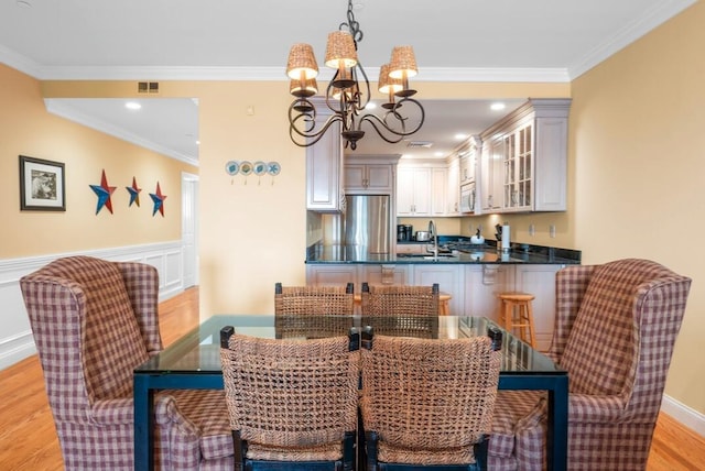 286 Grand Ave Unit 4U, Falmouth, MA 02540 - dining room featuring a chandelier, ornamental molding, and light wood-type flooring