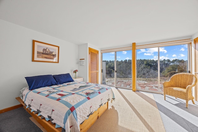 bedroom with expansive windows, carpet, and access to outside