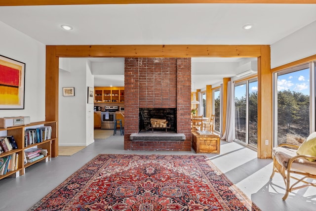 living room with a brick fireplace and a wall mounted AC