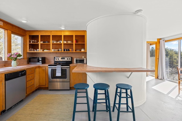 kitchen featuring a kitchen breakfast bar, kitchen peninsula, and appliances with stainless steel finishes