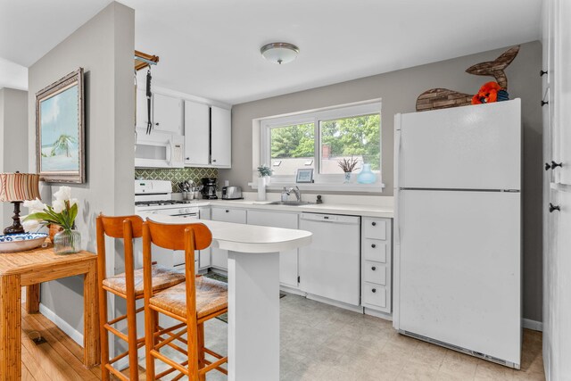 12 Running Light Way, Mashpee, MA 02649 - kitchen featuring white appliances, a sink, white cabinetry, light countertops, and backsplash