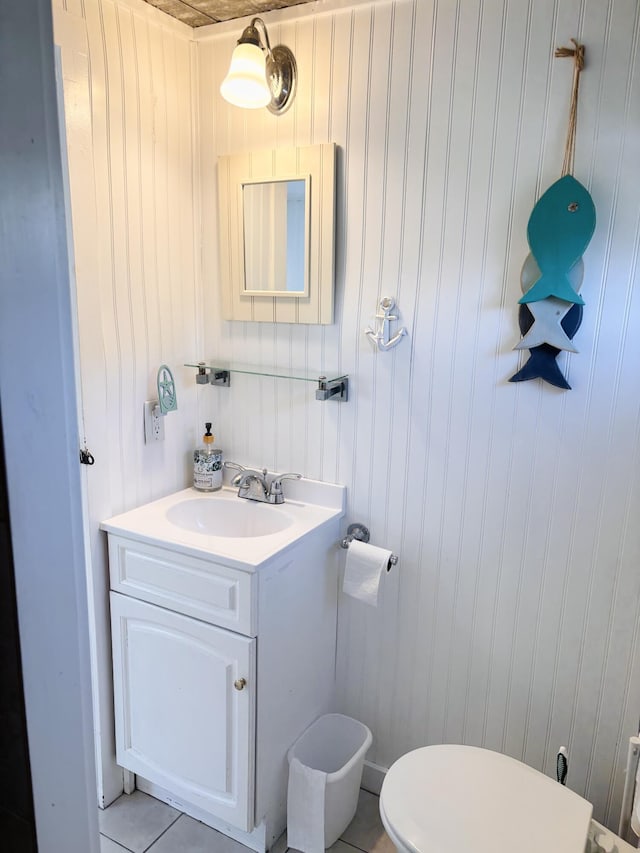 bathroom with toilet, tile patterned flooring, and vanity
