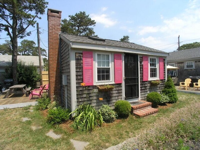 exterior space with a lawn, fence, a chimney, and entry steps