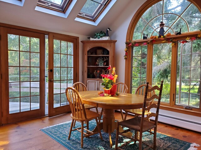 dining area featuring hardwood / wood-style flooring and lofted ceiling with skylight