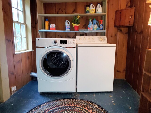 clothes washing area with independent washer and dryer and wooden walls