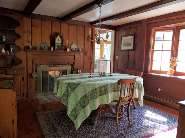 dining area featuring beam ceiling, wood-type flooring, and plenty of natural light