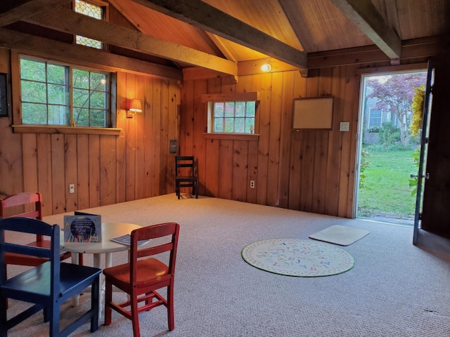 dining space with carpet floors, vaulted ceiling with beams, wooden ceiling, and wooden walls