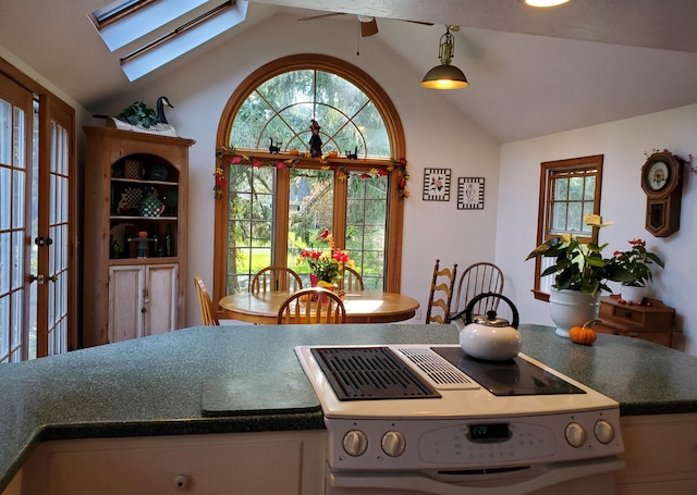 kitchen with lofted ceiling with skylight and range with electric stovetop