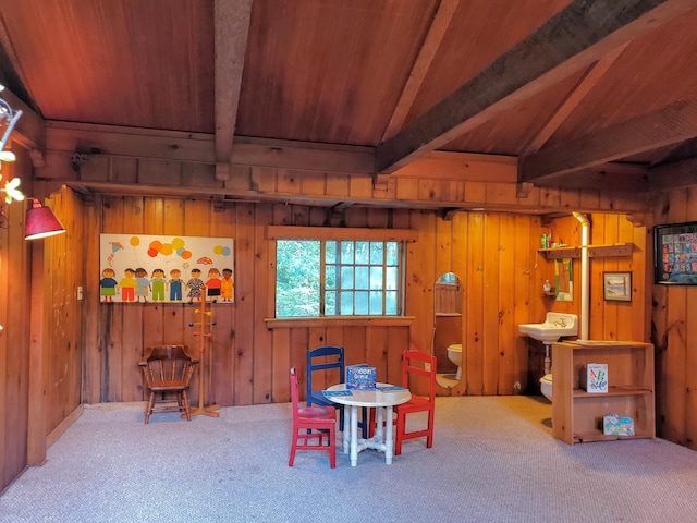 recreation room with lofted ceiling with beams, carpet floors, and wood walls