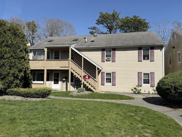back of property featuring stairs, a lawn, and a wooden deck