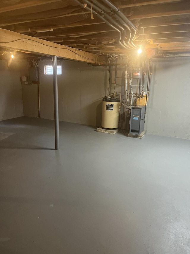 basement featuring electric panel and water heater