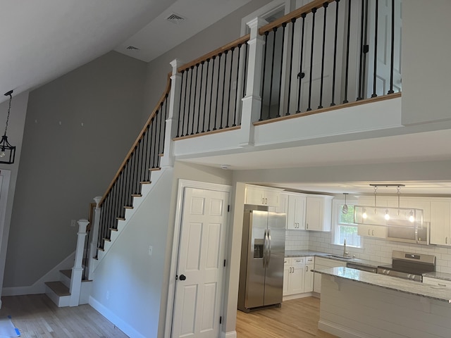 staircase with sink and hardwood / wood-style floors