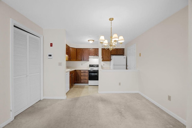 2 Englewood Dr Unit H-1, Harwich, MA 02645 - kitchen with white appliances, a chandelier, light carpet, light countertops, and hanging light fixtures