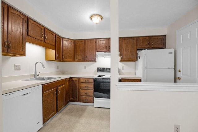 2 Englewood Dr Unit H-1, Harwich, MA 02645 - kitchen with white appliances, under cabinet range hood, light countertops, brown cabinetry, and light flooring
