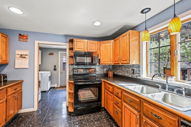 kitchen featuring black appliances, washing machine and dryer, decorative light fixtures, decorative backsplash, and sink