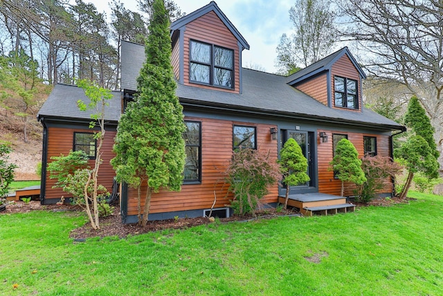 view of front facade with a front lawn and a shingled roof