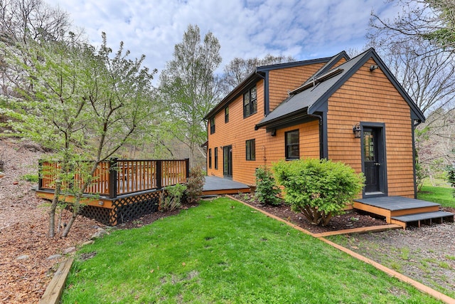 rear view of house with a wooden deck and a yard