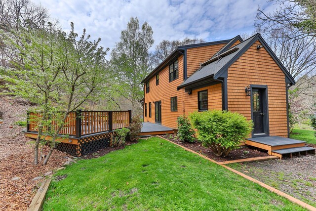 back of property featuring a lawn and a wooden deck