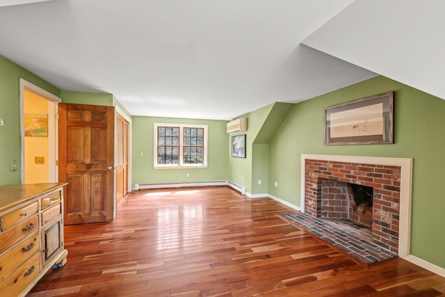 unfurnished living room with a brick fireplace, a baseboard heating unit, hardwood / wood-style floors, and a wall mounted AC