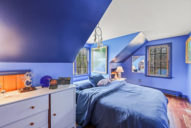 bedroom featuring wood-type flooring, a baseboard heating unit, and lofted ceiling