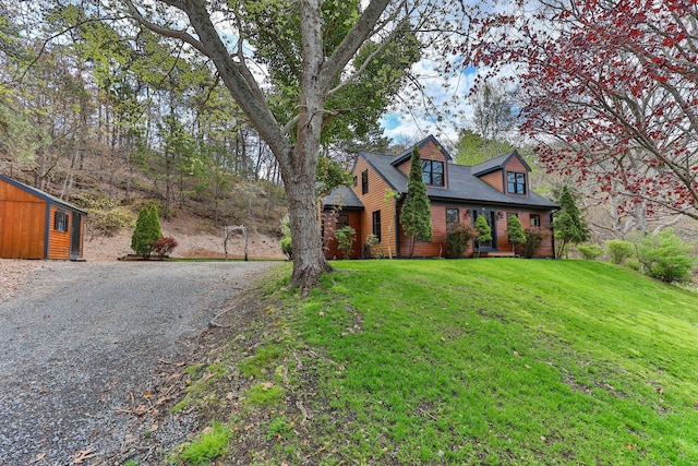 view of front of house with a front yard and an outbuilding