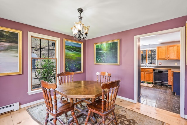 dining room with a chandelier and a baseboard heating unit