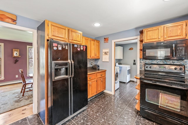 kitchen with baseboard heating, black appliances, washing machine and dryer, light brown cabinetry, and backsplash