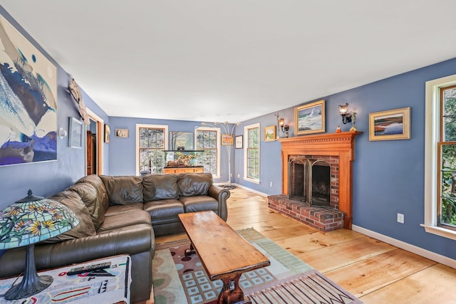 living room featuring a brick fireplace and wood-type flooring