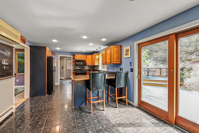 kitchen featuring black appliances, a baseboard heating unit, decorative backsplash, kitchen peninsula, and a breakfast bar area