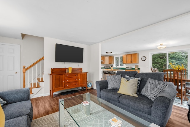 living area featuring stairway, wood finished floors, and baseboards