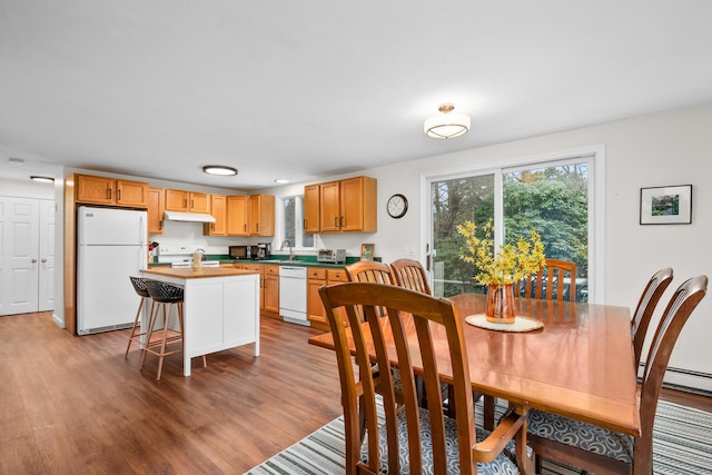 dining area featuring baseboard heating and wood finished floors