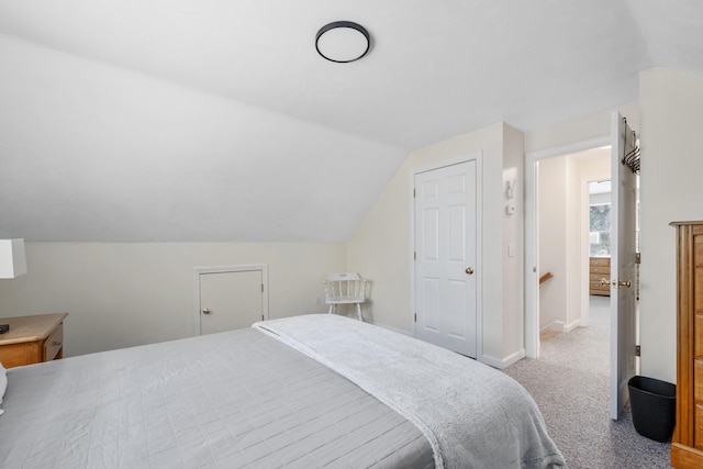 carpeted bedroom with baseboards and vaulted ceiling