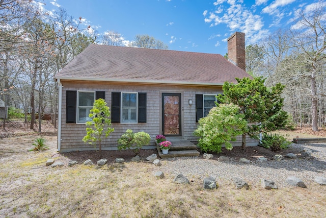 view of front of property with a chimney and roof with shingles